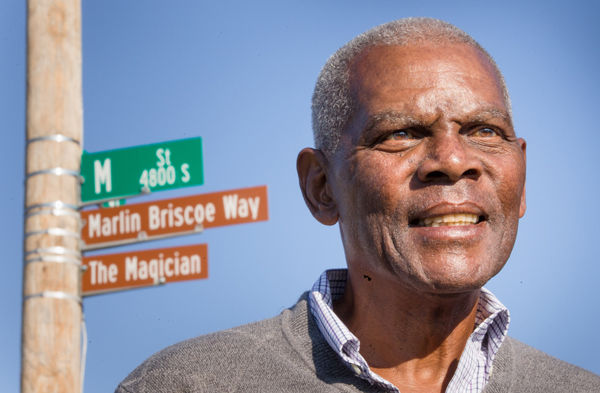 Marlin Briscoe stands in front of street sign for Marlin Briscoe Way